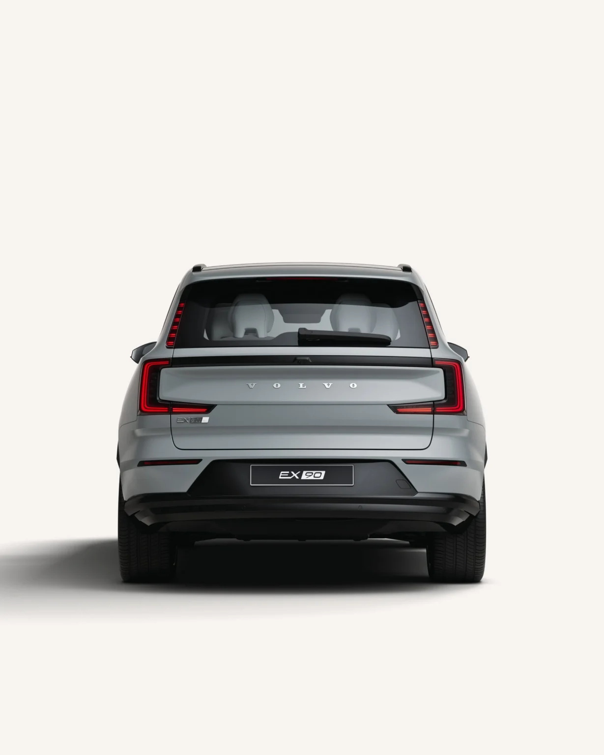 Grey Volvo EX90 seen from the rear in a white studio