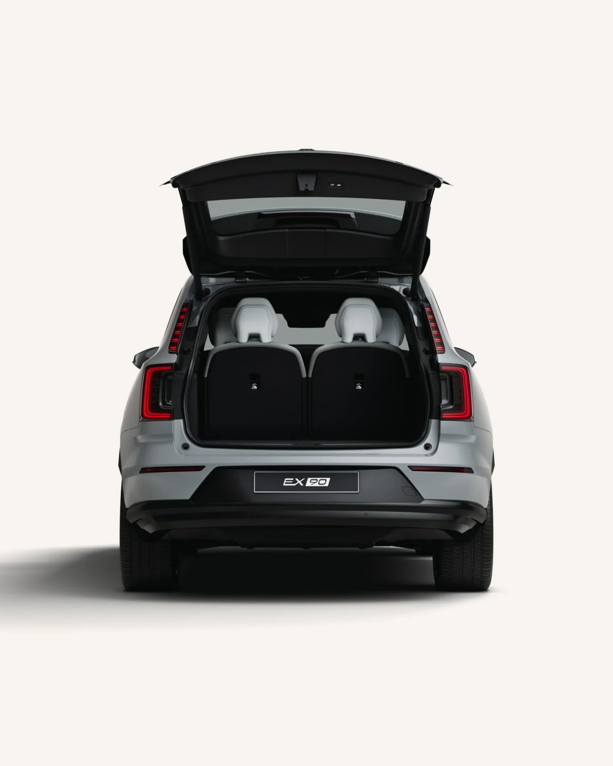 Grey Volvo EX90 from the rear with the tailgate open, showing the boot and third-row seats