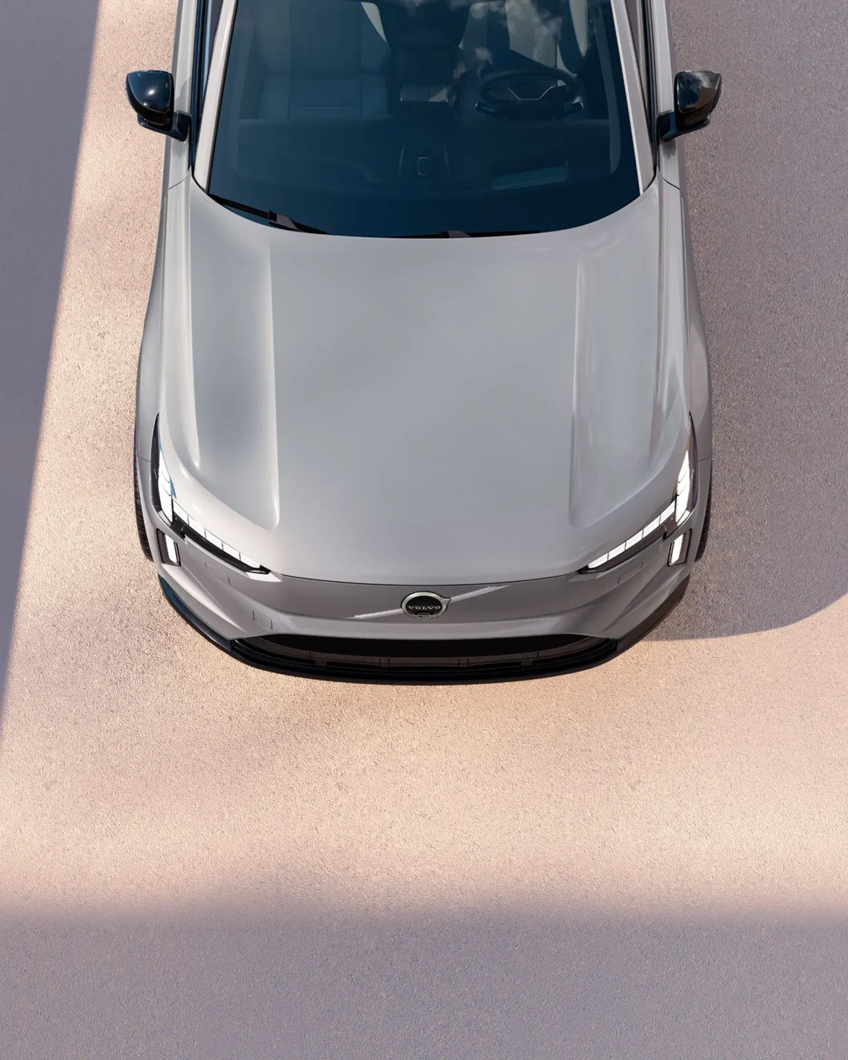 Pale grey Volvo EX90 seen from above the bonnet, showing its slim headlights