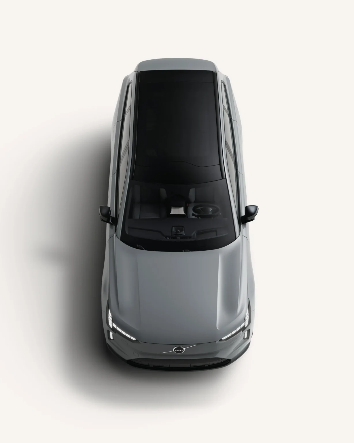 Grey Volvo EX90 seen from above in a white studio, showing its glass roof