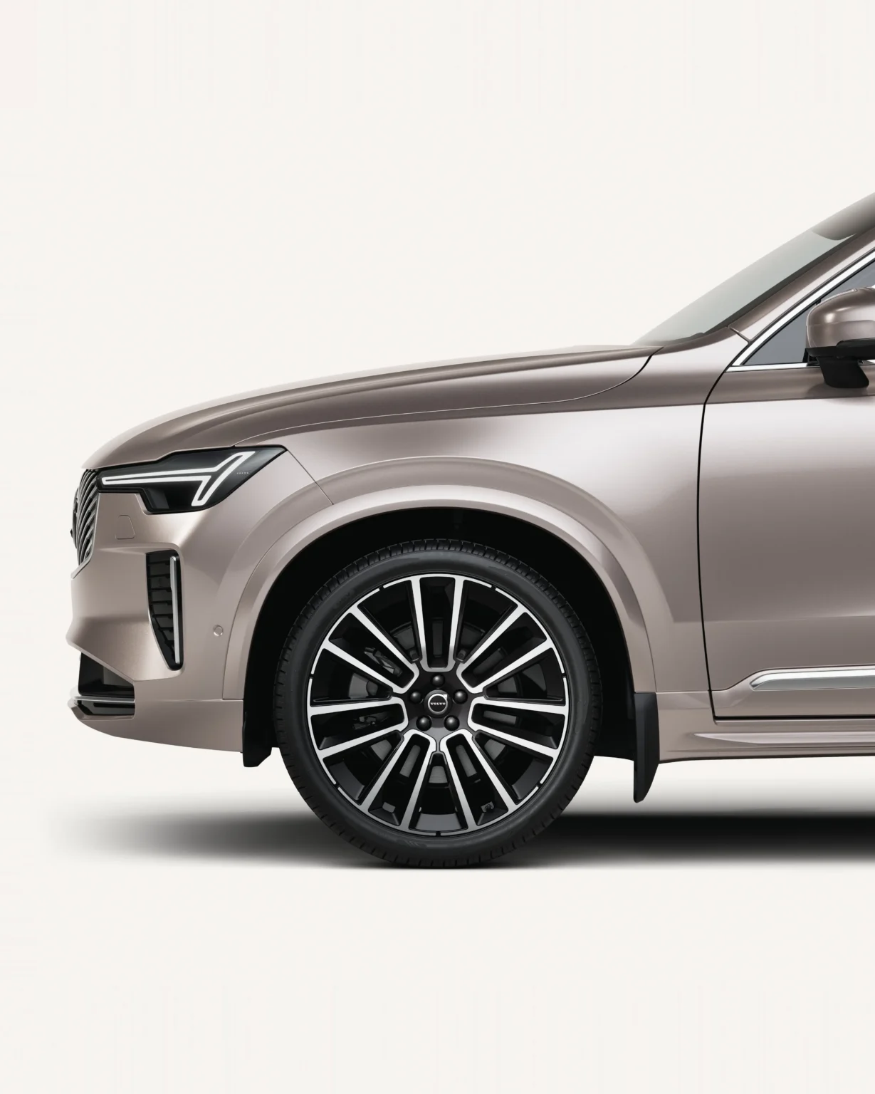 Front half of a Volvo XC90 in a white studio, showing its front wheel