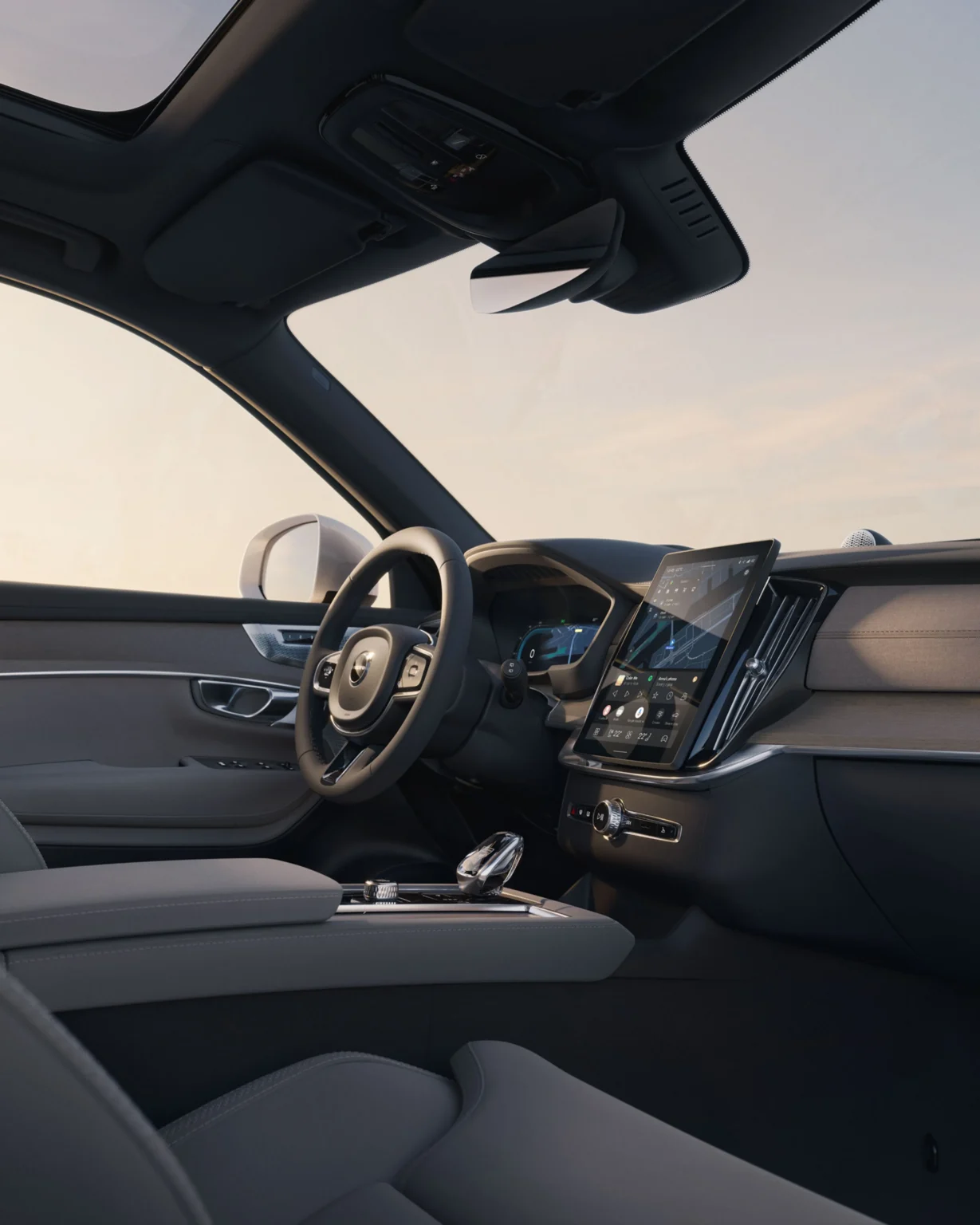 Volvo XC90 cockpit seen from the open driver's door, with the steering wheel and centre touchscreen
