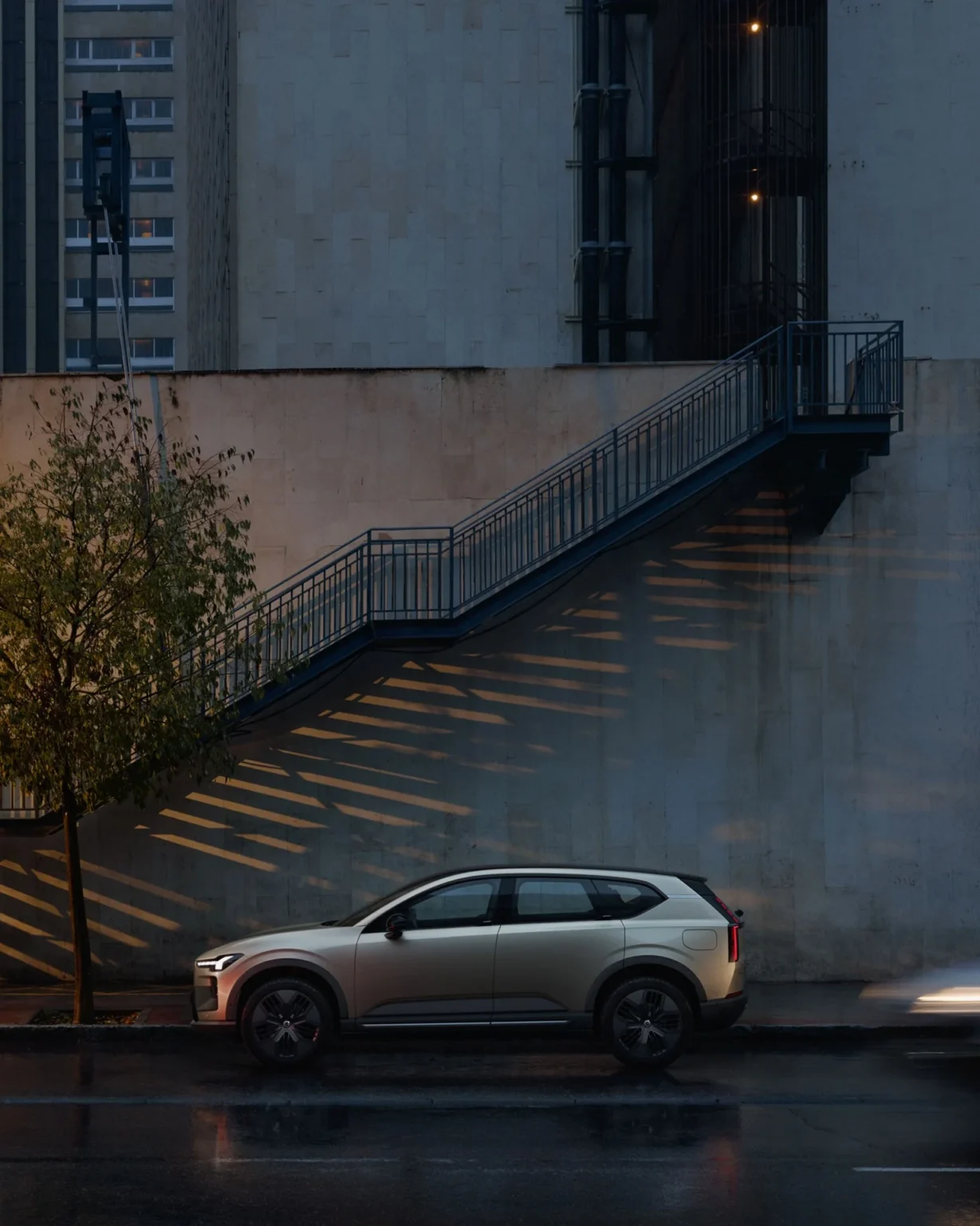 Side view of a Volvo EX60 Cross Country parked on a city street in the evening