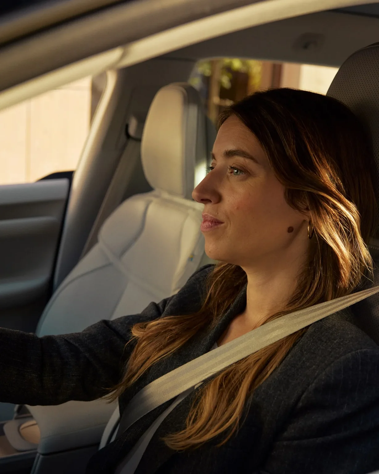 Driver in a Volvo EX60 wearing a seatbelt and looking ahead