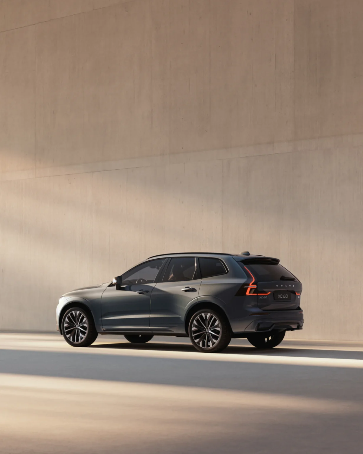 Volvo XC60 from the rear three-quarter in a sunlit concrete space