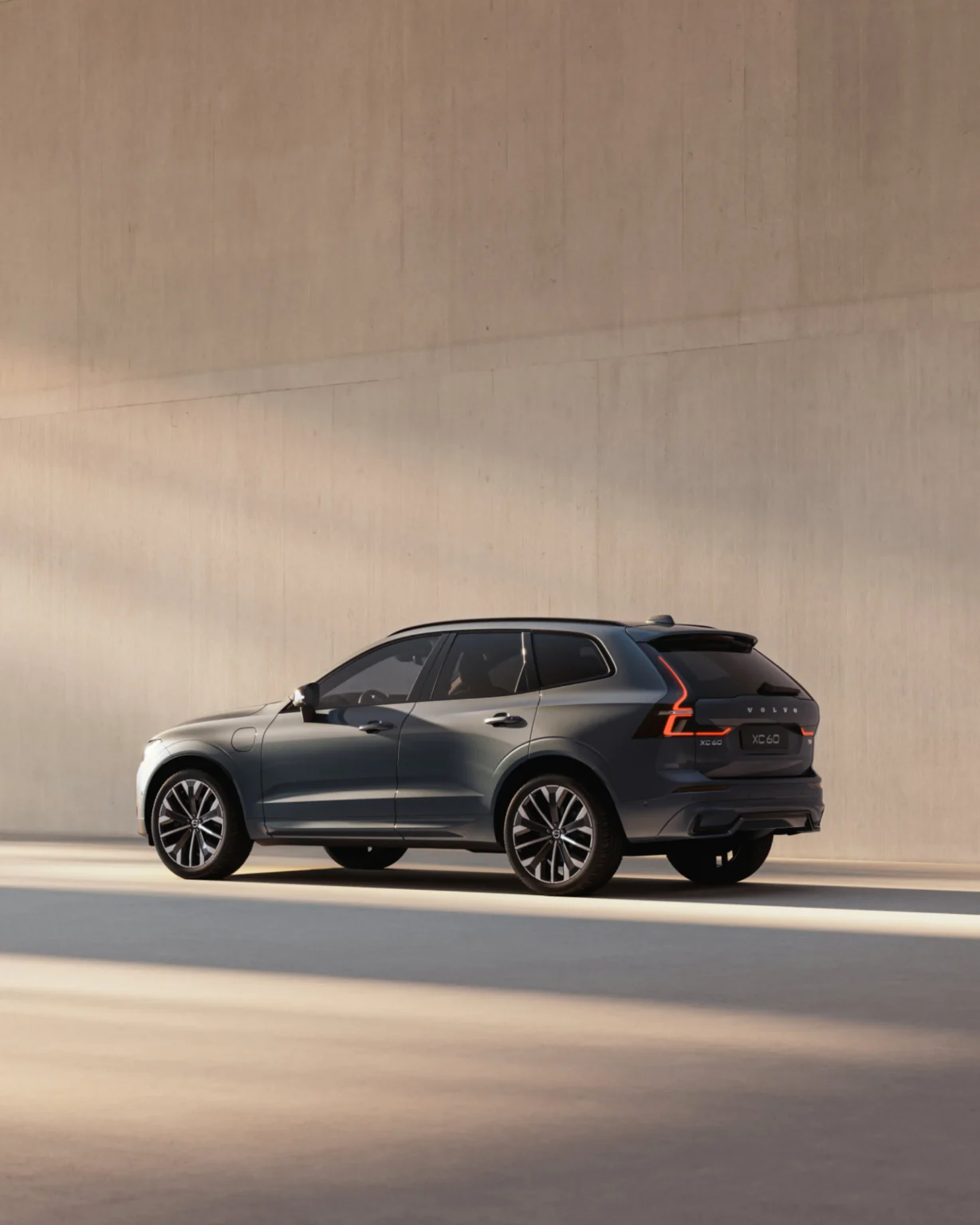 Volvo XC60 from the rear three-quarter in a sunlit concrete space