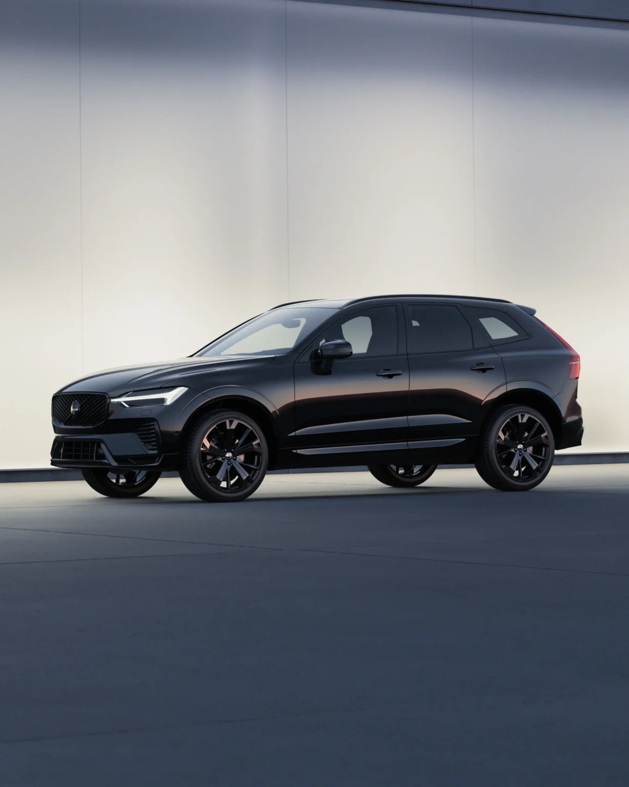 Black Volvo XC60 Black Edition from the front three-quarter in a softly lit studio